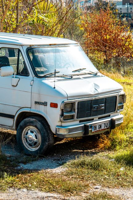 Close-up view of a MacBook Pro laptop displaying a code editor with HTML and Ruby code, positioned on a desk or table. The screen shows a webpage's source code with highlighted syntax in various colou